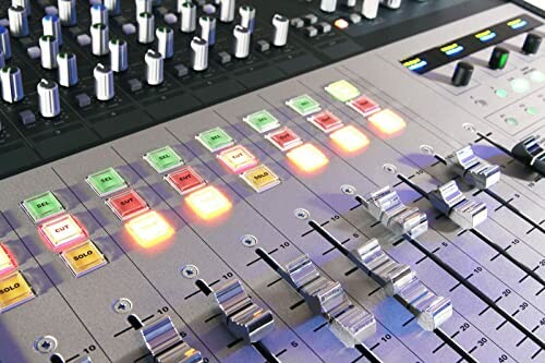 Close-up of a professional audio mixing console with illuminated buttons and faders.