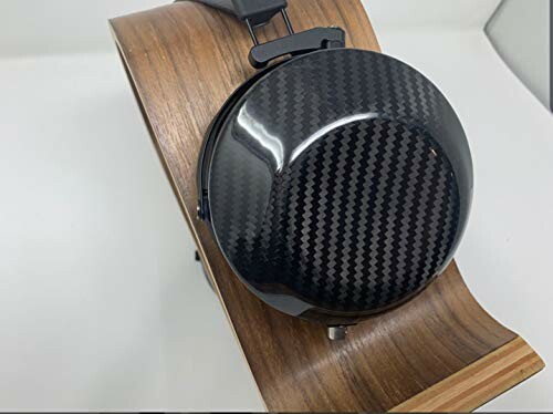 Carbon fiber headphone earcup on a wooden stand.