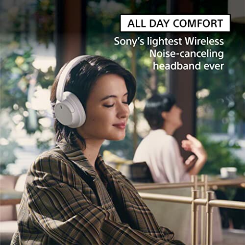 Person wearing Sony wireless noise-canceling headphones in a relaxed setting.