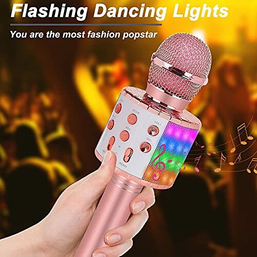 Hand holding a pink wireless karaoke microphone with flashing lights.